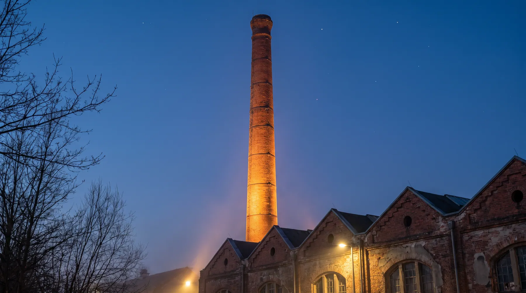 Beleuchteter Backsteinschornstein aus der Industriezeit